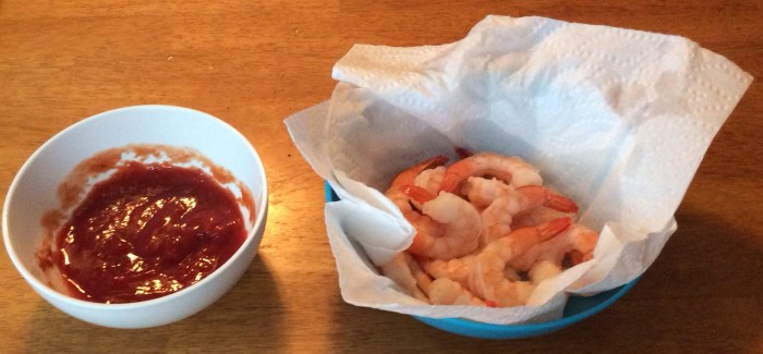 Take shrimp from right bowl. Hold by tail. Dip in tangy cocktail sauce in left bowl. Bite to fingers holding said tail.