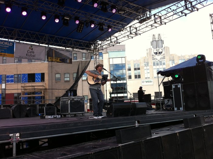 Tim Herron plays on the main stage of Taste of Syracuse, with the National Grid building in the background.