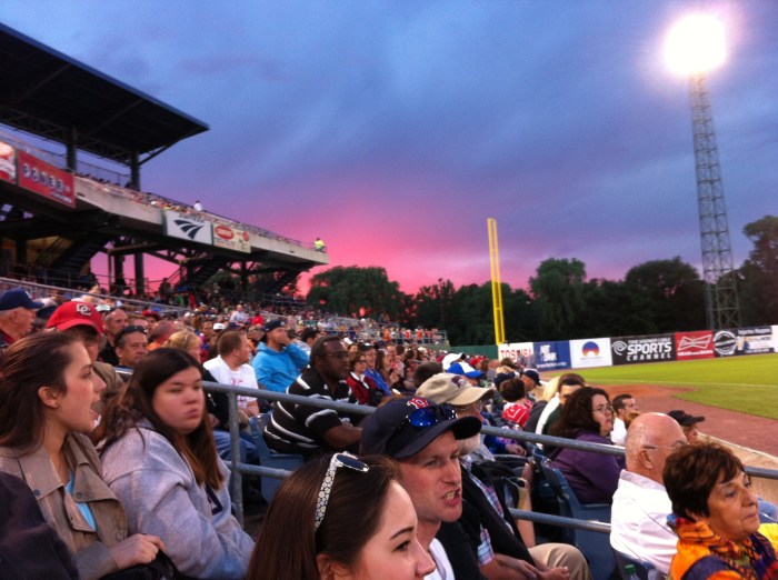 Over the left field stands, a pretty sunset.