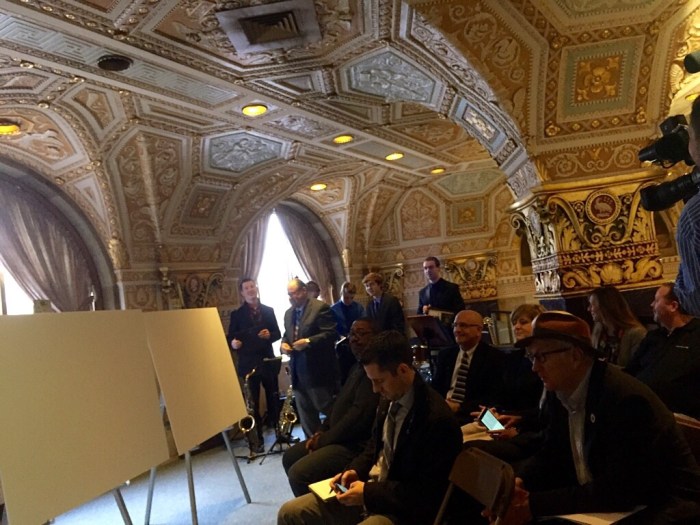 Back at the M&T Syracuse Jazz Fest news conference in the downtown bank lobby, fest founder and director Frank Malfitano hangs with the young musicians of band Notified as press and dignitaries wait for the unveiling of the acts.
