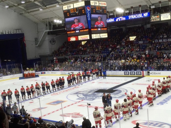 The players are at attention, ready to play, as Syracuse Crunch captain Mike Angelides is announced last.