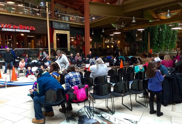 Interested model car enthusiasts around the track. 